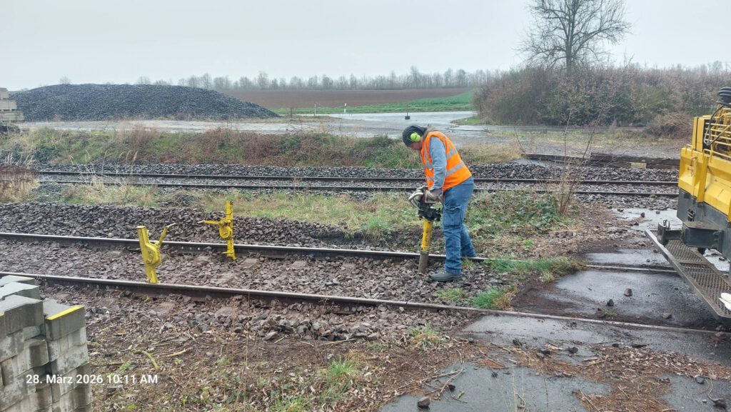 Das gehobene Gleis wird von Hand gestopft