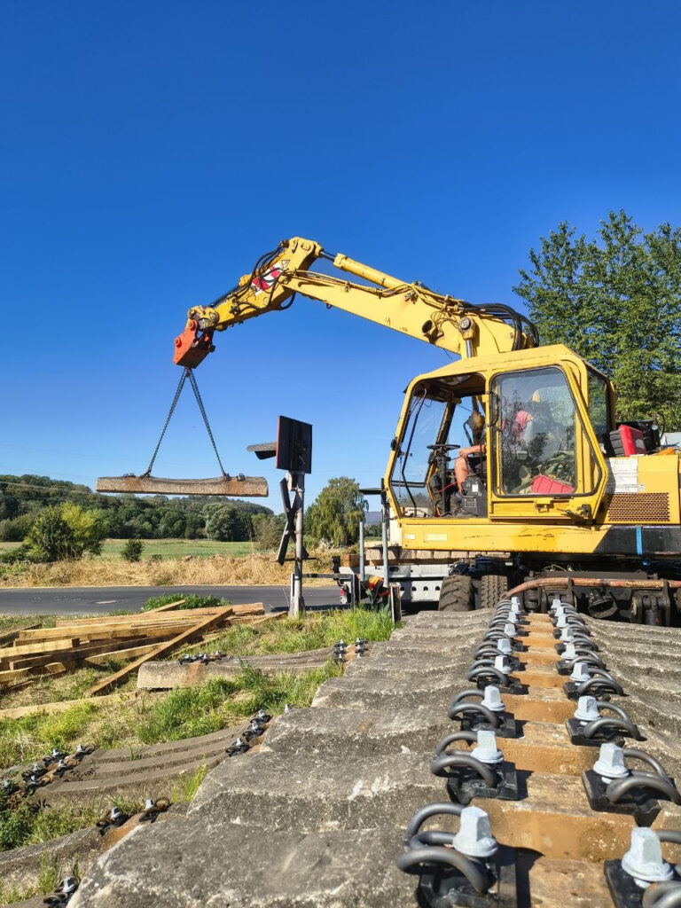 Mit dem Bagger werden die Schwellen abgeladen